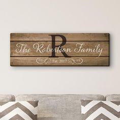 a wooden sign that reads the robertson family on it's wall above a couch