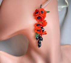 an orange flower bracelet on a mannequin's head with beads and leaves