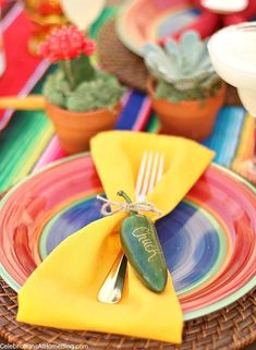 a table set with colorful plates and place settings