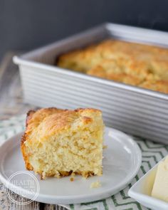 a piece of cake sitting on top of a white plate next to a loaf of bread