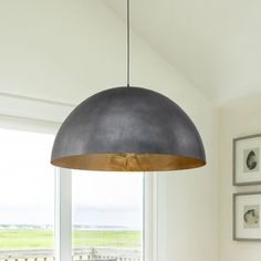 a dining room table with chairs and a lamp hanging from it's center point