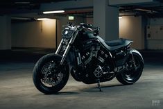 a black motorcycle is parked in an empty parking garage with no one on it's bike