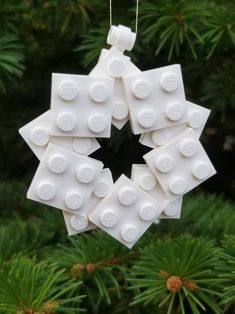 a christmas ornament made out of legos is hanging from a pine tree