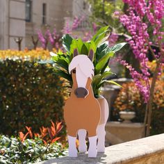 a horse shaped planter sitting on top of a stone wall