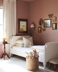 a white day bed sitting in a bedroom next to a window with pictures on the wall