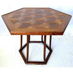 a wooden table with a diamond pattern on it's top and bottom, sitting on a white background