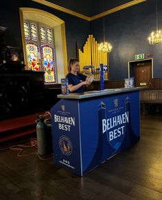 a person standing at a bar in front of a stained glass window with the words bel haven best on it