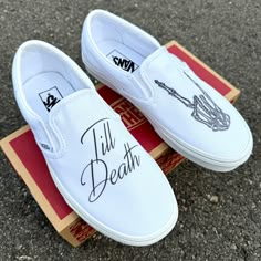 two white shoes that have writing on them