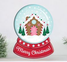 a snow globe with a gingerbread house in the center and merry christmas written on it