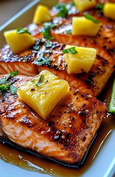 grilled salmon with pineapple and cucumber garnish on a plate