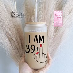 a person holding up a drink with the words i am 39 plus on it and an image of a hand that is pointing down