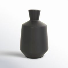 a black vase sitting on top of a white table