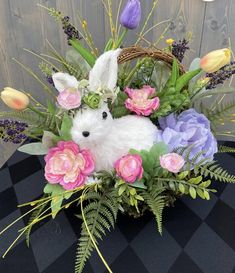 a basket filled with flowers on top of a black and white checkered table cloth