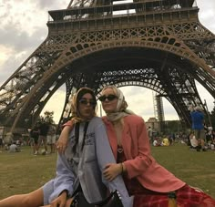 two women pose in front of the eiffel tower