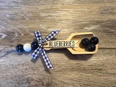 a wooden spoon with some black and white balls in it on top of a table