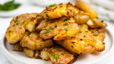 a white plate topped with fried potatoes and garnished with parsley