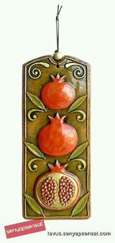 a ceramic ornament with two pomegranates on it's sides