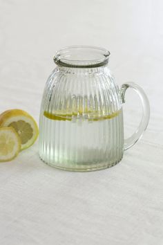 a glass tea pot with lemon slices on the side