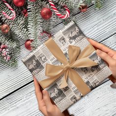 a person holding a wrapped present in front of a christmas tree with candy canes