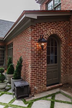 a brick house with green grass in the front yard and an air conditioner outside