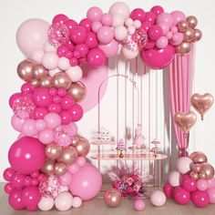 a pink and gold party with balloons on the wall