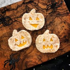 two crackers decorated like jack - o'- lanterns on a wooden board