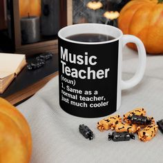 a coffee mug with words on it next to some cookies and pumpkins in the background