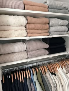 an organized closet with folded sweaters and pants