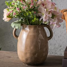 a vase filled with flowers sitting on top of a wooden table