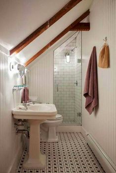 a bathroom with a sink, toilet and shower stall in the corner on the wall