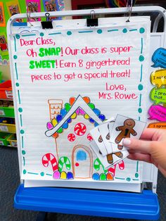 a hand holding up a piece of paper that says, dear class, on snap our class is super sweet fan & gingerbread pieces to get a special treat i love mrs rowe