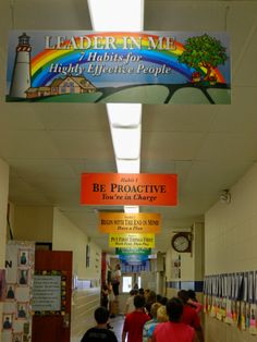 there are many people walking down the hallway in front of banners that say leaders come