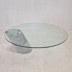 a round glass table with a concrete base