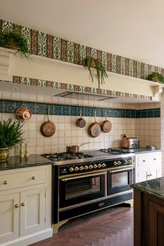 a stove top oven sitting inside of a kitchen next to a counter with pots and pans on it