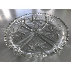 a clear glass bowl with two toothbrushes in the center on a metal surface