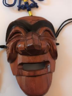 a wooden mask hanging on a wall