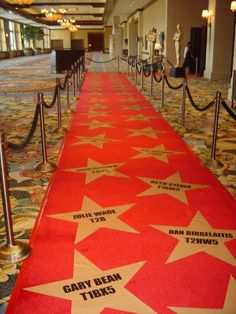 a red carpet with white stars and black writing on it in an airport lobby area