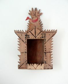 a wooden frame with a bird on it and an arrow in the middle is shown