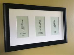 three framed pictures hanging on the wall in front of a white wall with black frame