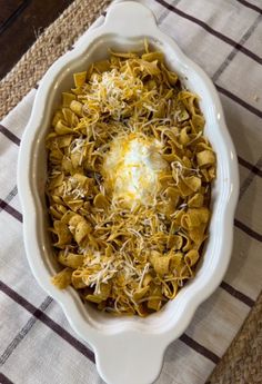 a casserole dish filled with pasta and cheese on a checkered table cloth