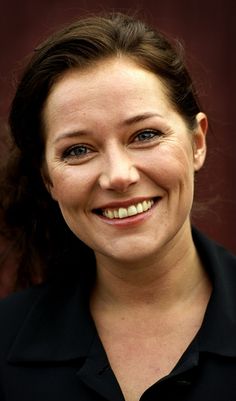 a woman smiling and wearing a black shirt