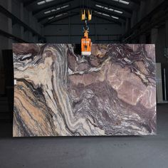 a large marble counter top in an industrial building with yellow and orange lights hanging from the ceiling