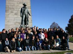 a group of people posing in front of a statue