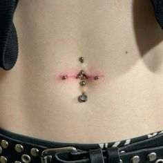 a woman's stomach with beads and piercings on it