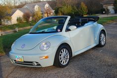 a white convertible car parked in front of a house