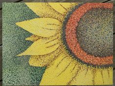 a drawing of a sunflower with colored pencils in it's center on a wooden surface