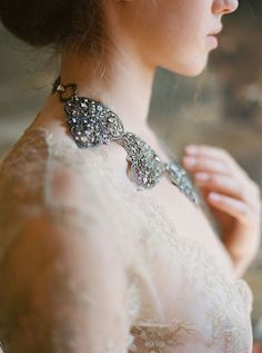 a woman in a white dress wearing an elaborate necklace