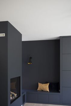 an empty room with a fireplace and built - in storage units on the side wall