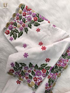 two pieces of white cloth with colorful flowers on them