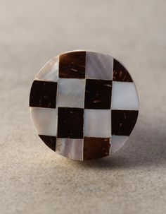 a black and white checkered button sitting on top of a table